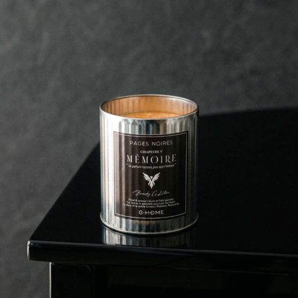 Bougie artisanale pour homme Mémoire G-HOME posée au bord d'un piano sombre avec une ambiance sobre et silencieuse