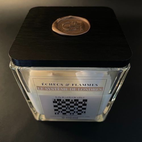 Bougie artisanale premium en verre carré avec couvercle noir. Une création G-HOME inspirée de l’ouverture du Système de Londres aux échecs.